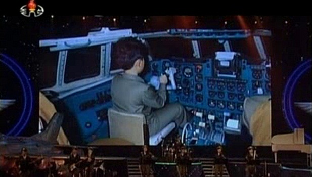 O pequeno ditador: telão mostra Kim Jong-un durante sua infância. Nesta imagem ele está dentro da cabine de um avião