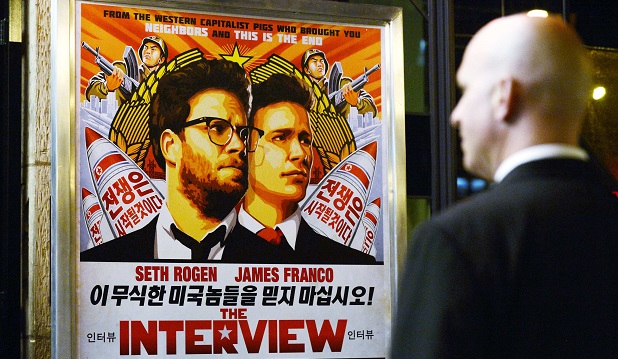 Segurança observa cartaz do filme 'A Entrevista' nos EUA; comédia virou estopim para incidente diplomático