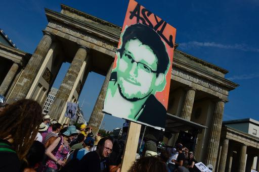 Manifestantes seguram um cartaz em apoio ao ex-consultor da Agência Nacional de Segurança americana (NSA) Edward Snowden, em frente ao Portão de Brandemburgo, em Berlim, em 27 de julho de 2013