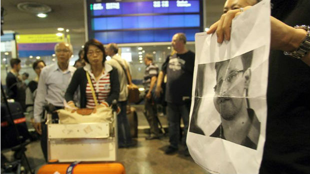 Jornalistas mostram foto de Edward Snowden a passageiros do voo de Hong Kong a Moscou