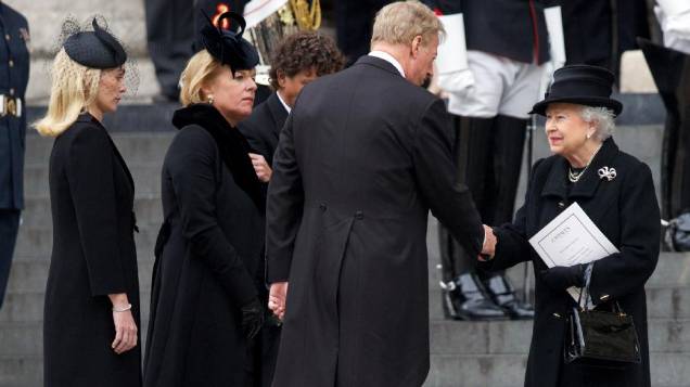 A rainha Elizabeth II cumprimenta Mark Thatcher, filho de Margareth Thatcher, em frente à Catedral de Saint Paul, onde ocorreu o funeral da ex-premiê