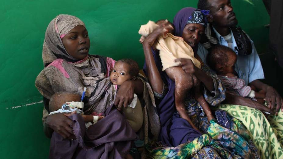 Pais aguardam para pesar seus filhos doentes e desnutridos no hospital Banadir, em Mogadíscio, Somália