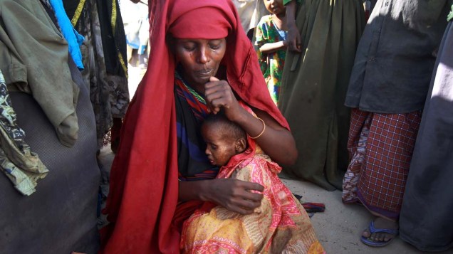 Mulher somali com seu filho doente de sarampo em acampamento em Mogadíscio, Somália