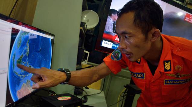 Oficial da Agência Nacional de Busca e Resgate da Indonésia aponta a posição onde a aeronave desapareceu