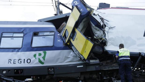 Policial observa estragos em trens que colidiram frontalmente perto da estação Granges-près-Marnand, oeste da Suíça