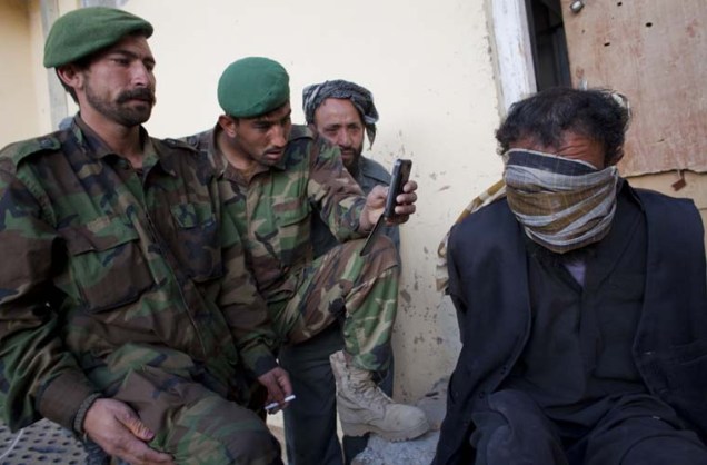 Talibã detido pelas tropas americanas. Foram encontrados em sua casa propaganda pró-talibã, morteiros e munições.