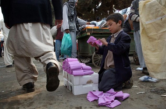 Menino vende papel higiênico nas ruas da capital Cabul. Cerca de 60.000 crianças trabalham nas ruas do Afeganistão.