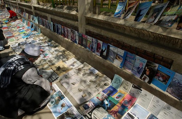 Homem lê jornal em Cabul. O governo do Afeganistão exerce forte censura sobre a mídia.