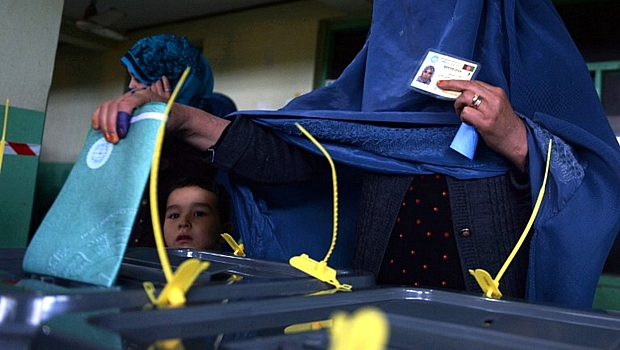 Mulher afegã deposita voto: oito candidatos concorrem nas eleições presidenciais no país