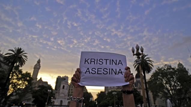 Manifestantes seguram cartazes durante protesto realizado na Praça de Maio, em Buenos Aires