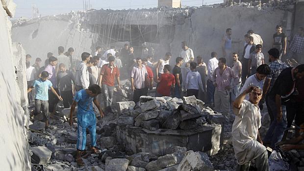 Sírios procuram corpos em edifício após bombardeio aéreo em Alepo