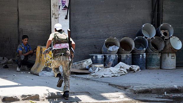 Soldados do Exército Sírio Livre (ESL) combatem as tropas de Assad no bairro de Shaar, em Alepo