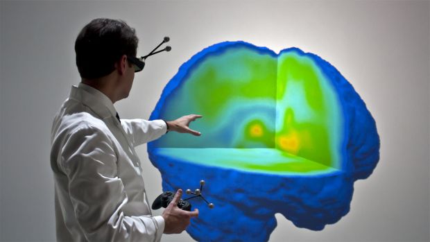 O brasileiro Alexandre Dasilva, diretor de um laboratório da Universidade de Michigan, nos Estados Unidos, que estuda a enxaqueca, em frente à imagem em 3D do cérebro de um paciente
