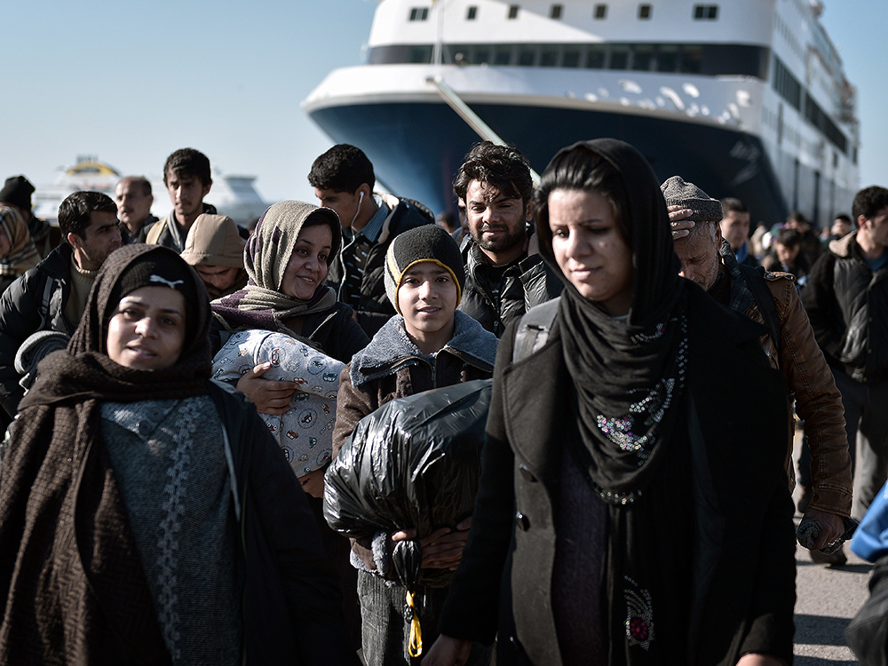 Milhares de refugiados atravessam a pé o porto de Pireu, na Grécia, depois de chegar ao país pela ilha de Lesbos. Em média, mais de 1.900 refugiados chegam por mês à Grécia em embarcações lotadas, segundo a ONU (Organização das Nações Unidas). A multidão costuma vir, na sua maioria, da Síria, que vive uma guerra civil