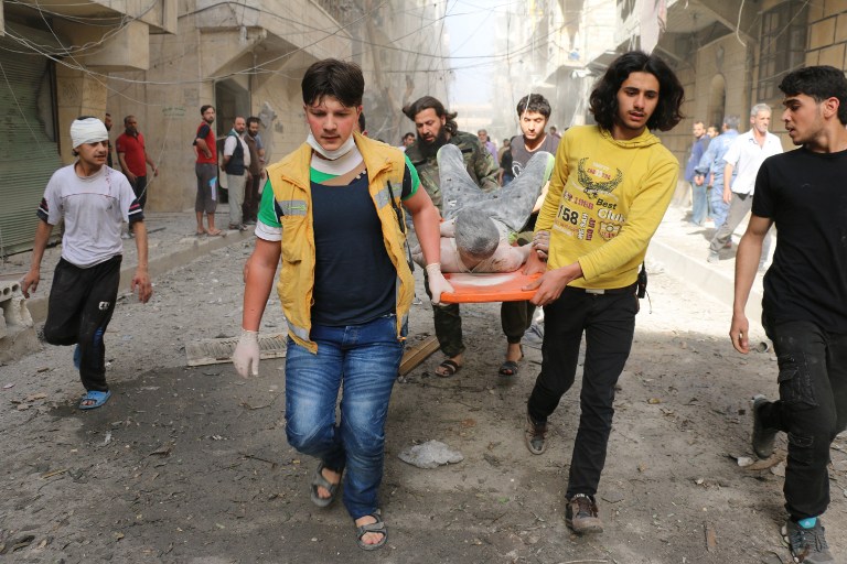Sírios carregam jovem ferido em bombardeio em reduto rebelde nos arredores da cidade de Aleppo, em 26 de abril de 2016