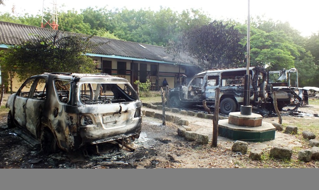 Carros de polícia queimados em frente a uma delegacia em Mpeketoni, no Quênia