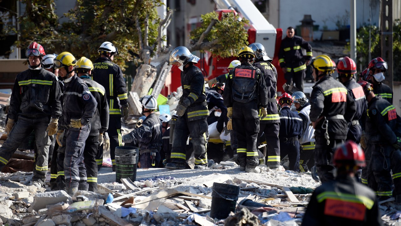 Bombeiros fazem buscas em escombros de prédio de quatro andares que desabou na periferia de Paris depois de uma explosão