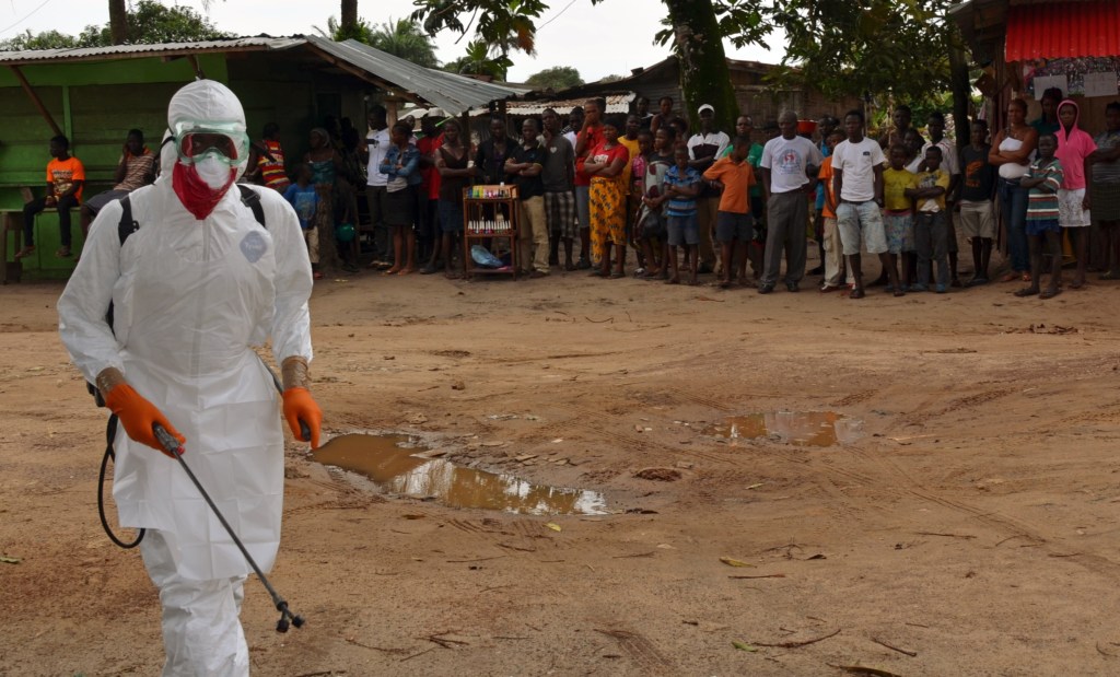 Profissional de saúde da Cruz Vermelha desinfeta local onde corpo de paciente infectado pelo ebola foi encontrado, em 10 de setembro, na Libéria