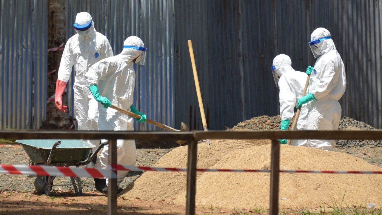 Profissionais de saúde da Libéria em tanque de areia que é utilizado para absorver os fluidos do corpo de vítimas do ebola