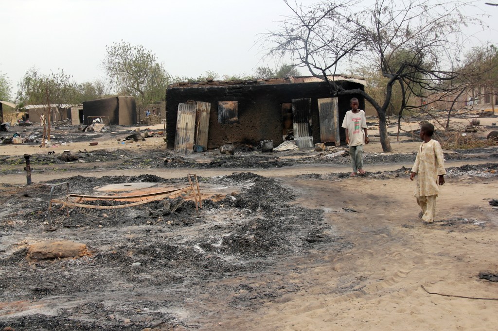 Foto de abril de 2013 mostra crianças perto de vila incendiada em Baga, no Estado de Borno, nordeste da Nigéria, depois de confrontos entre membros de força-tarefa conjunta e terroristas do Boko Haram, que fizeram novo ataque à localidade na última semana