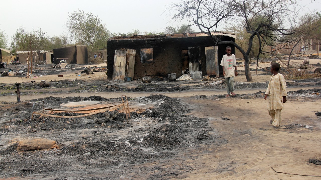 Foto de abril de 2013 mostra crianças perto de vila incendiada em Baga, no Estado de Borno, nordeste da Nigéria, depois de confrontos entre membros de força-tarefa conjunta e terroristas do Boko Haram, que fizeram novo ataque à localidade na última semana