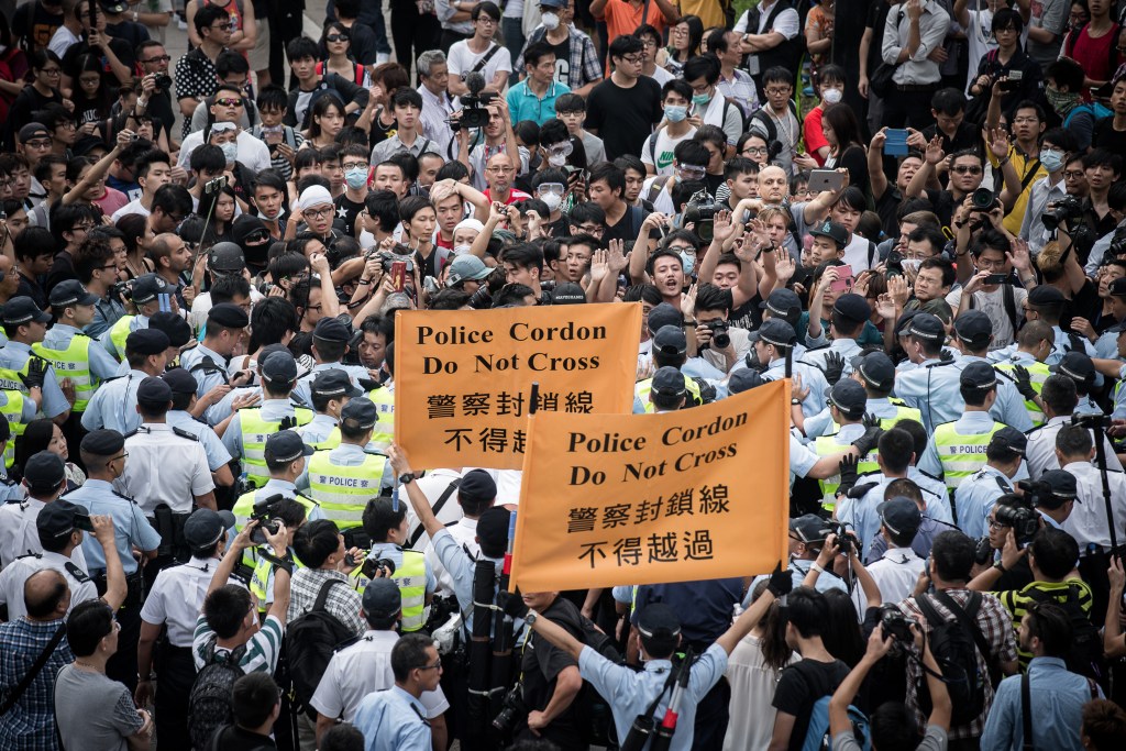 Cordão policial é formado para separar manifestantes pró-democracia de grupos contrários ao movimento em Hong Kong