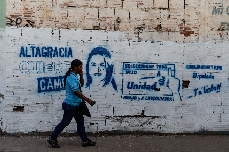 Mulher caminha em Altagracia de Orituco, na Venezuela, onde candidato da oposição foi morto durante comício