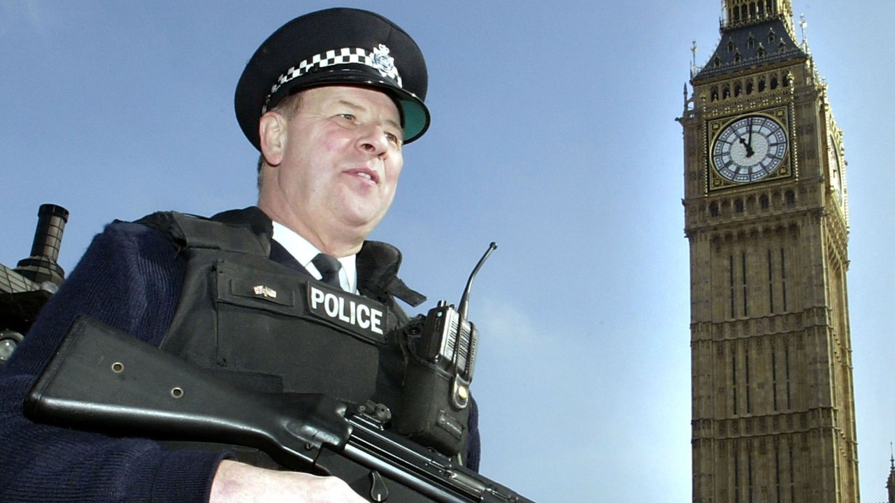 Policial patrulha os portões externos do Parlamento britânico