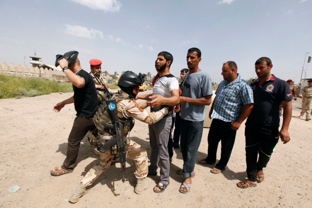 Voluntários são revistados antes de se juntarem ao Exército iraquiano na luta contra os terroristas do EIIL