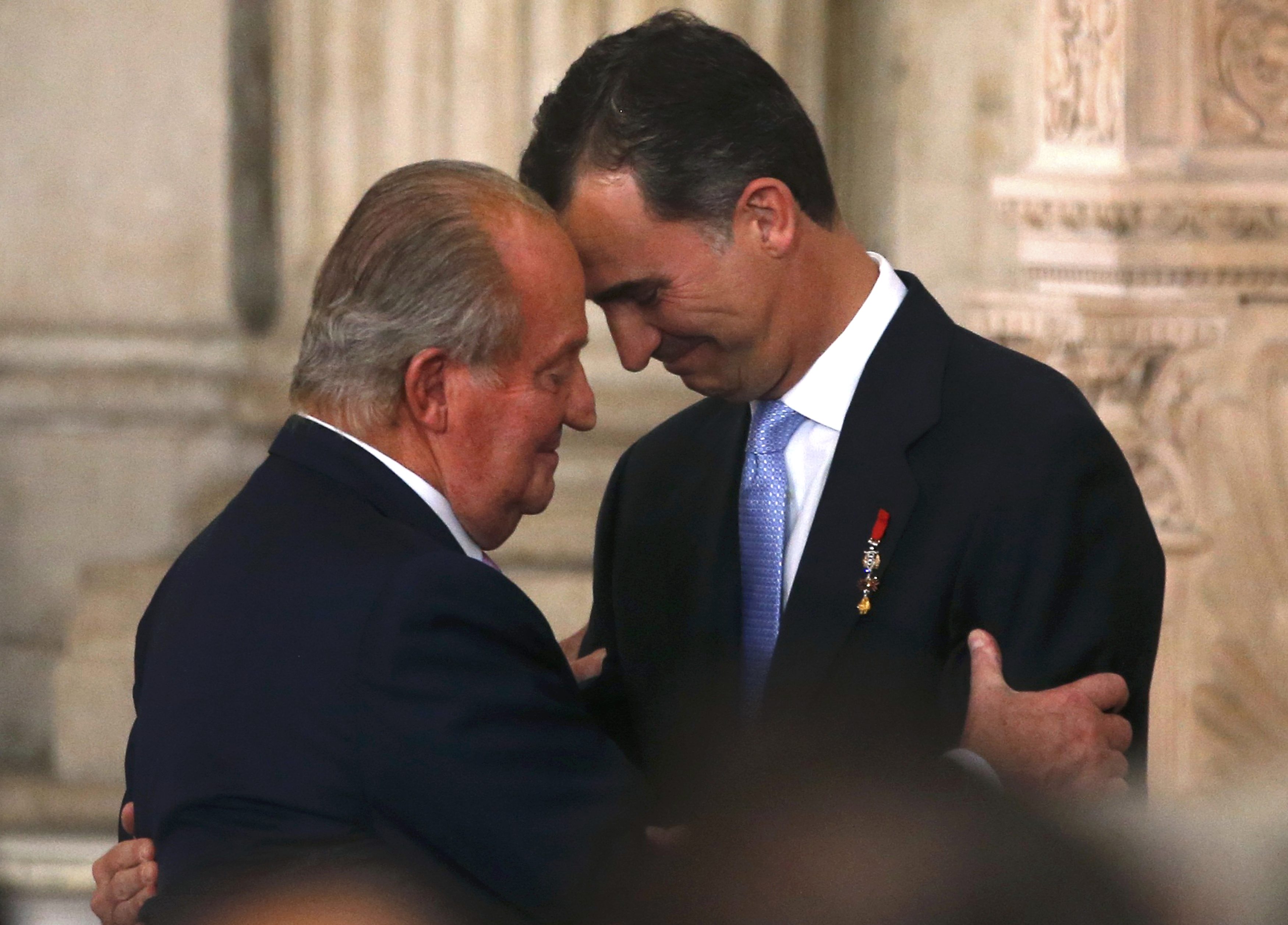 O rei Juan Carlos e seu filho, o príncipe Felipe, durante a cerimônia de assinatura da lei que formalizou a abdicação, no Palácio Real, em Madri