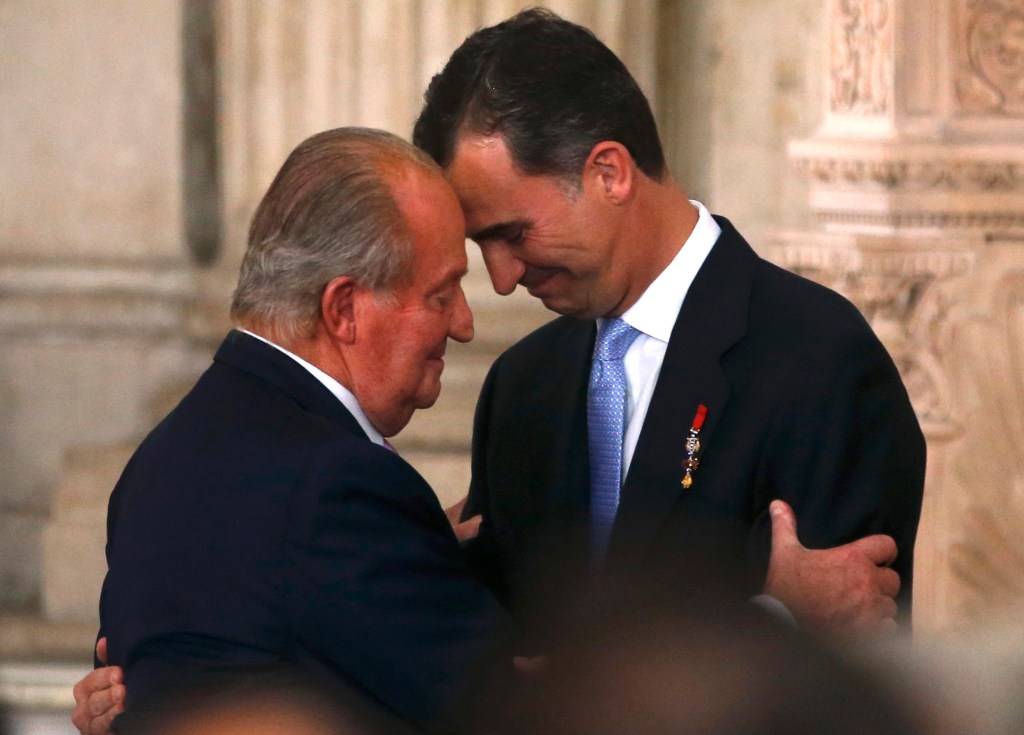 O rei Juan Carlos e seu filho, o príncipe Felipe, durante a cerimônia de assinatura da lei que formalizou a abdicação, no Palácio Real, em Madri