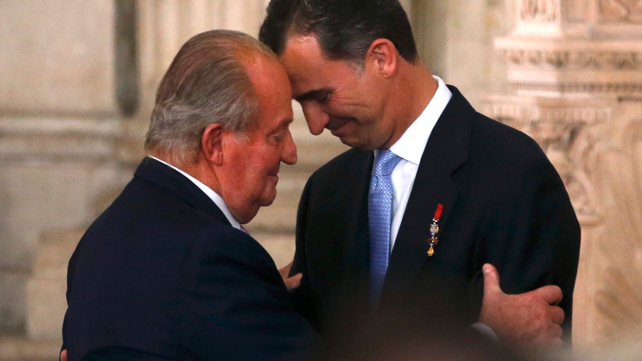 O rei Juan Carlos e seu filho, o príncipe Felipe, durante a cerimônia de assinatura da lei que formalizou a abdicação, no Palácio Real, em Madri