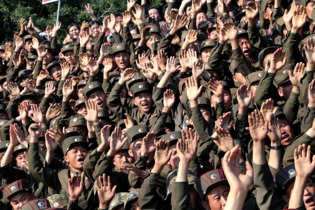 Soldados norte-coreanos acenam durante visita do ditador Kim Jong-un a ilha Ung