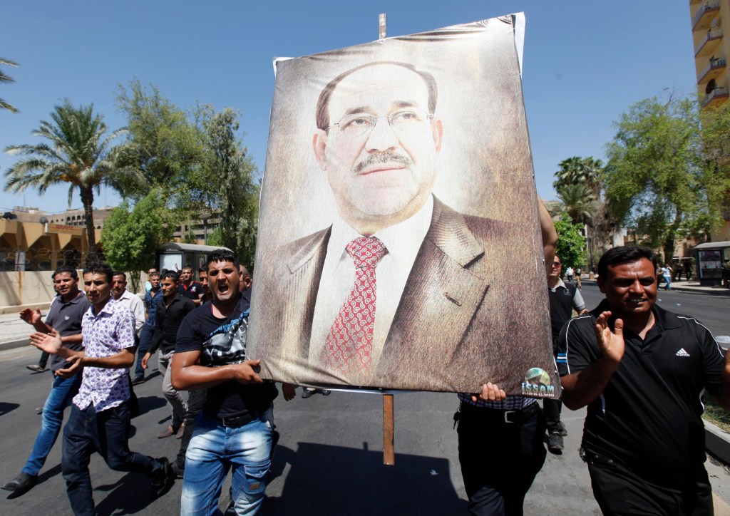 Iraquianos carregam desenho do primeiro-ministro Nouri al Maliki em marcha a favor do governo em Bagdá