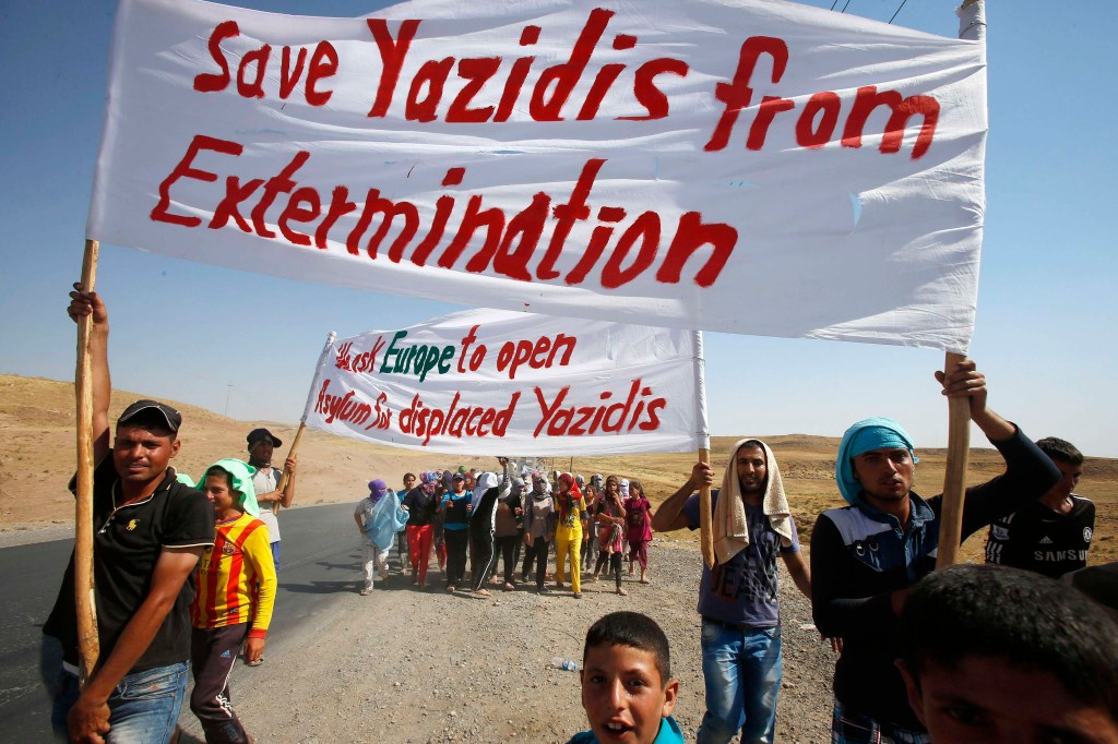 Yazidis que fugiram dos terroristas do Estado Islâmico no Iraque fazem marcha na fronteira com a Síria