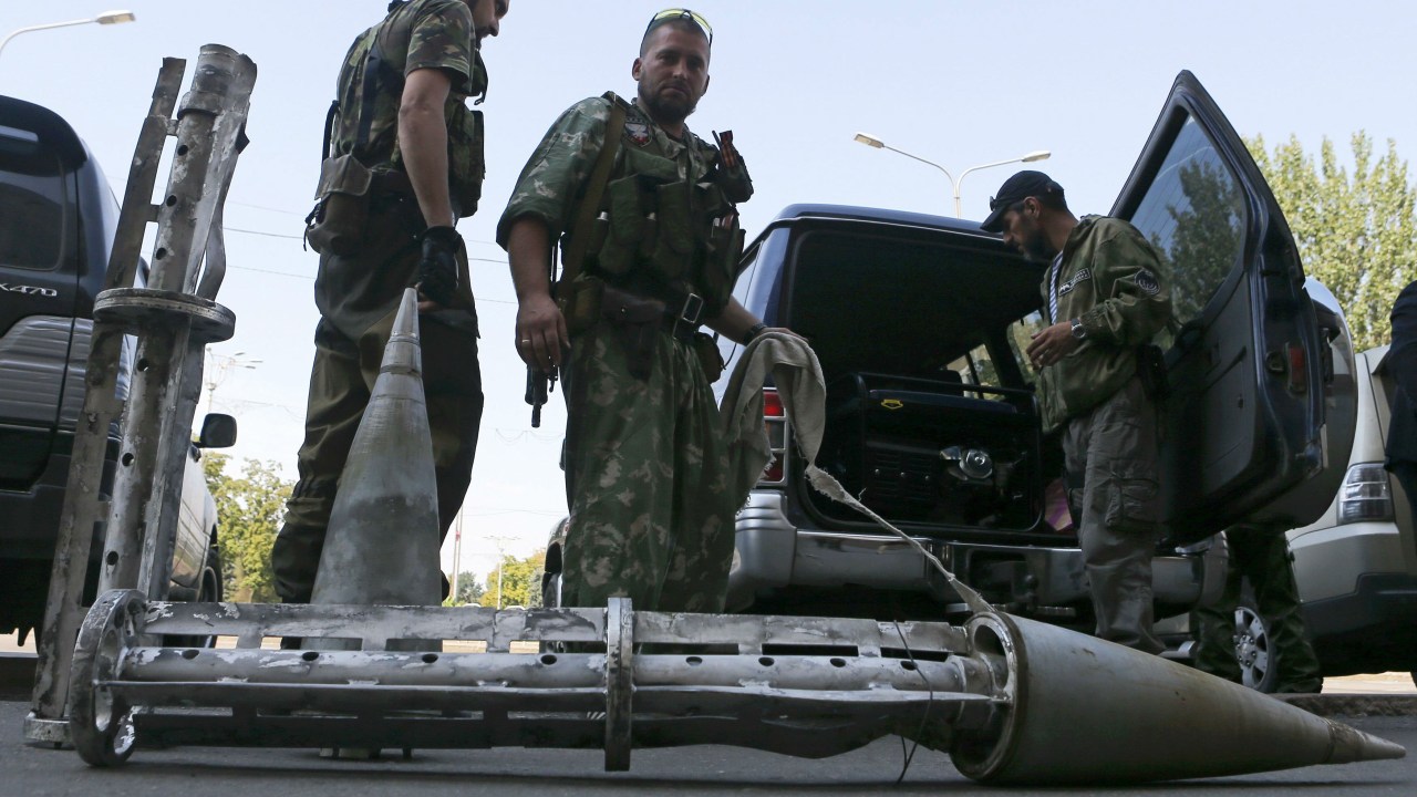 Rebeldes ucranianos são fotografados em frente a uma peça de artilharia usada em Donetsk