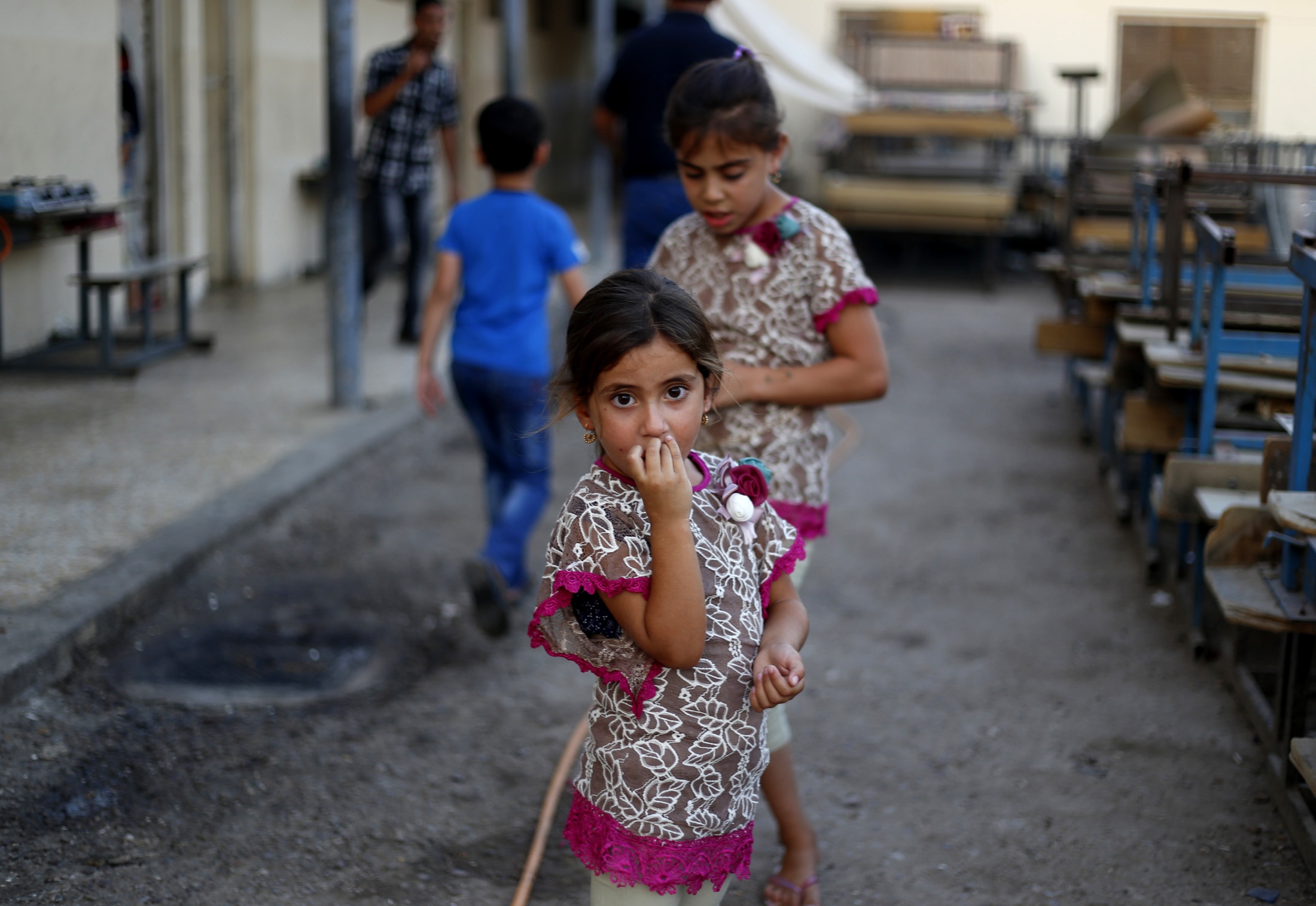 Garota iraquiana, que fugiu da violência da cidade de Mosul, parada em frente à escola em Bagdá, Iraque