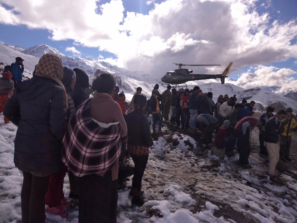 Pessoas observam helicóptero do Exército do Nepal usado no resgate a vítimas de avalanche