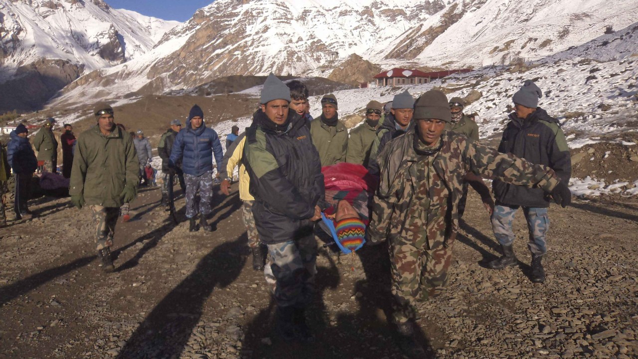Equipes resgatam uma das vítimas das tempestades de neve que atingiram o Nepal