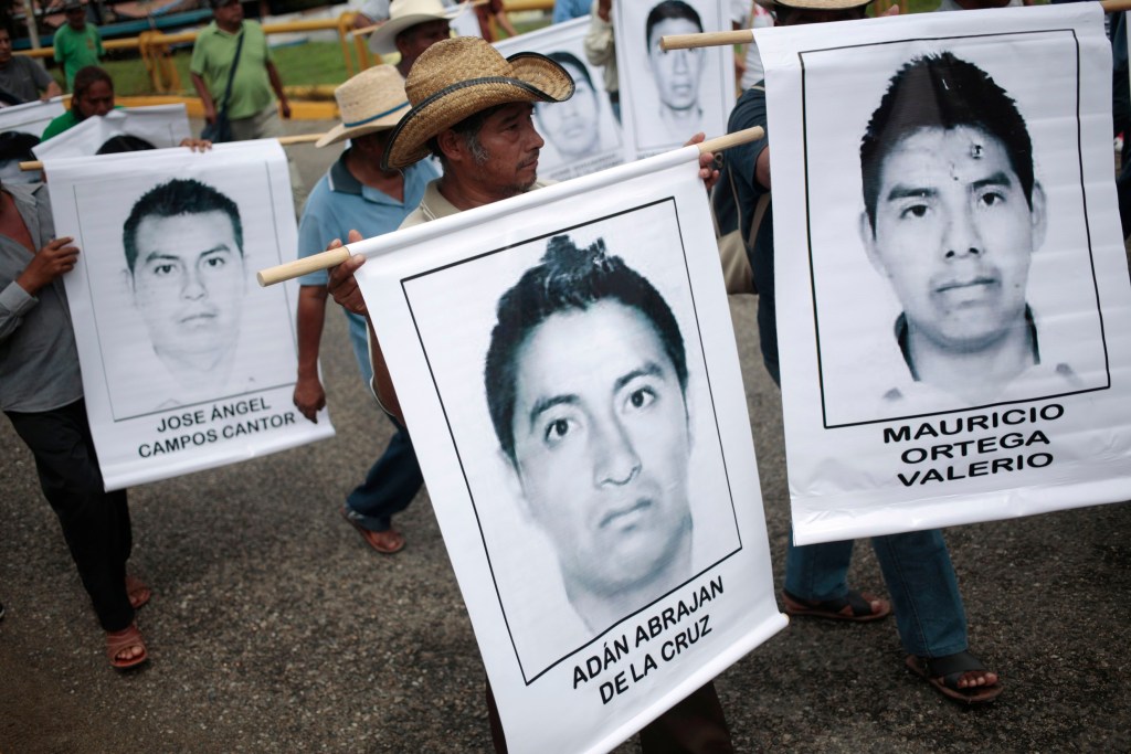 Pessoas levam imagens de estudantes desaparecidos durante protesto em Acapulco, no México