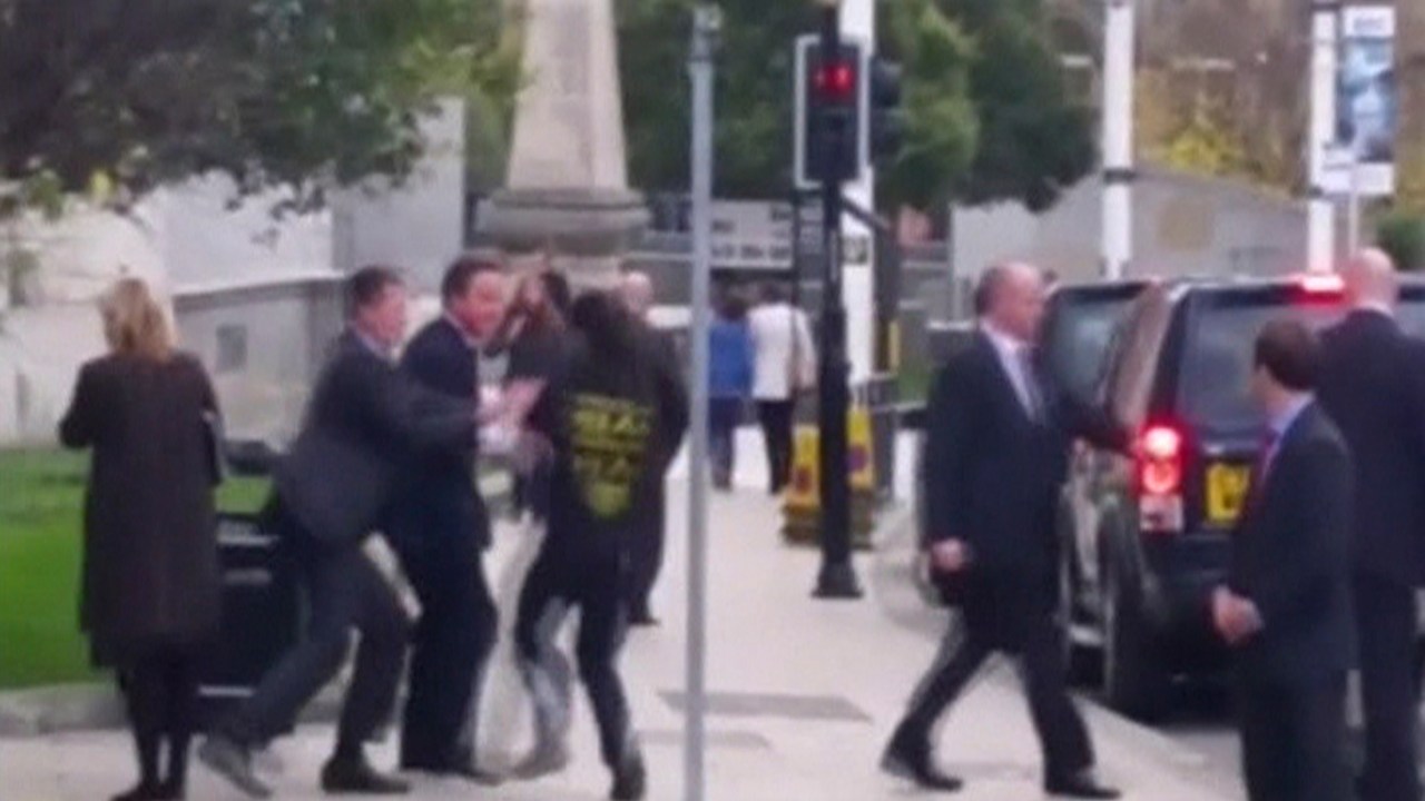 Imagem de vídeo que flagrou o momento em que um homem esbarrou com o primeiro-ministro britânico David Cameron, expondo uma falha na segurança