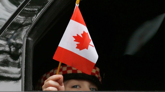 Marcus Cirillo, filho do soldado Nathan, morto no ataque ao Parlamento canadense, carrega uma bandeira do país durante o funeral do pai