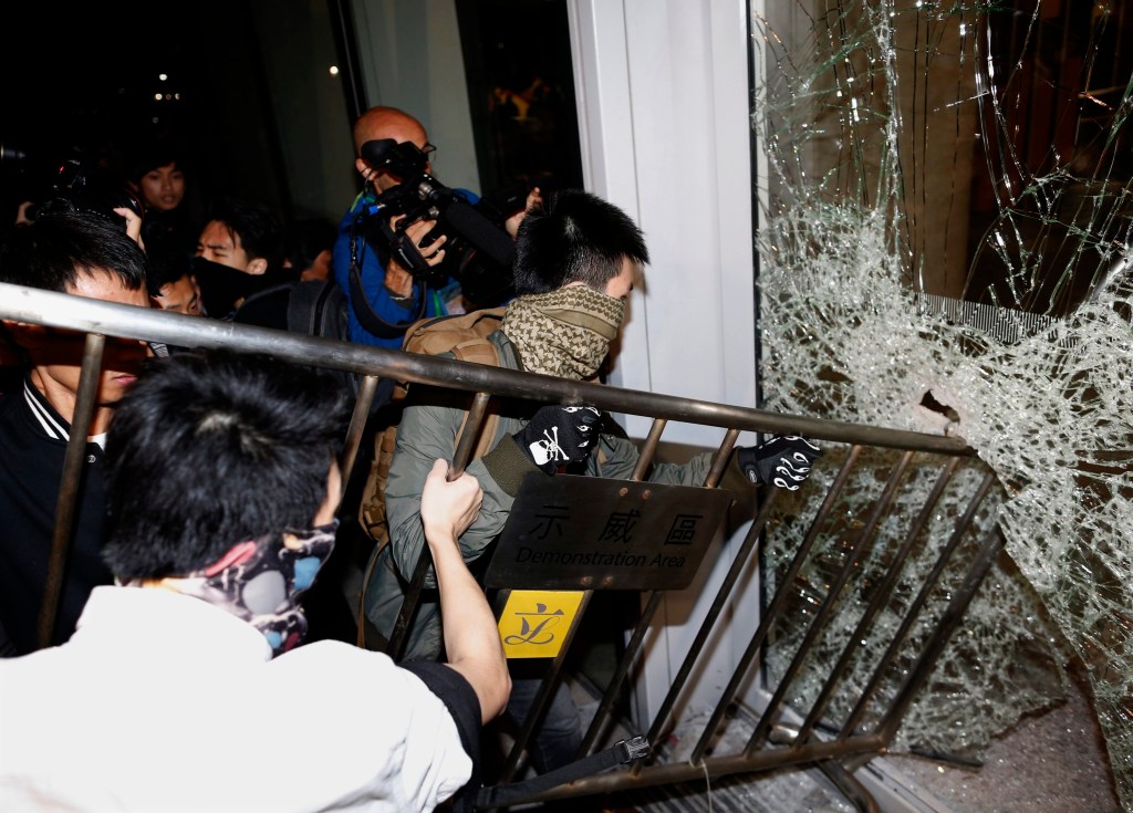 Manifestantes usam grade para tentar quebrar porta de vidro do prédio do Legislativo em Hong Kong