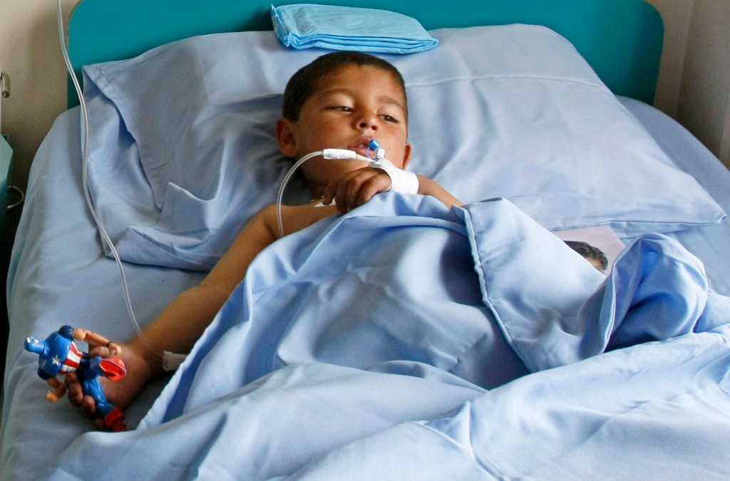 Menino recebe tratamento em hospital de Cabul depois de ficar ferido em ataque suicida durante jogo de vôlei no distrito de Paktika