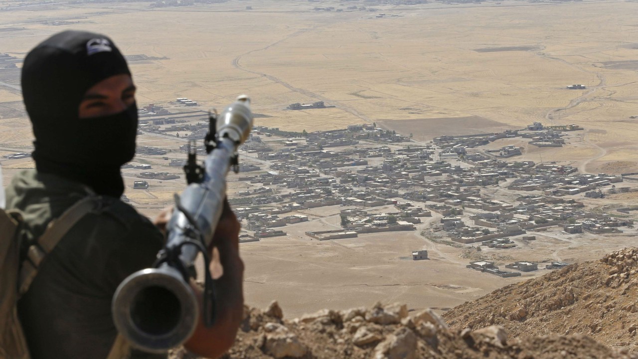 Combatente curdo se prepara para atacar vilarejo iraquiano dominado pelo grupo terrorista Estado Islâmico (EI)