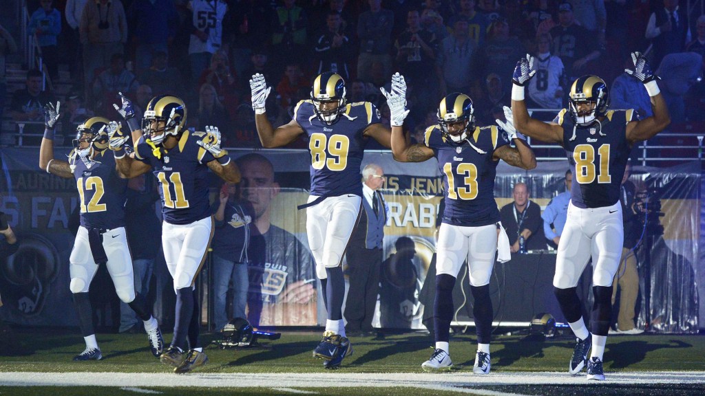 Jogadores de futebol-americano do St. Louis Rams fazem gesto em apoio aos manifestantes de Ferguson