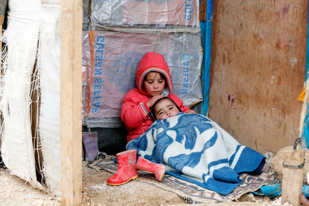 Menina síria é fotografada com o irmão em um assentamento improvisado no Vale do Beqaa, no Líbano