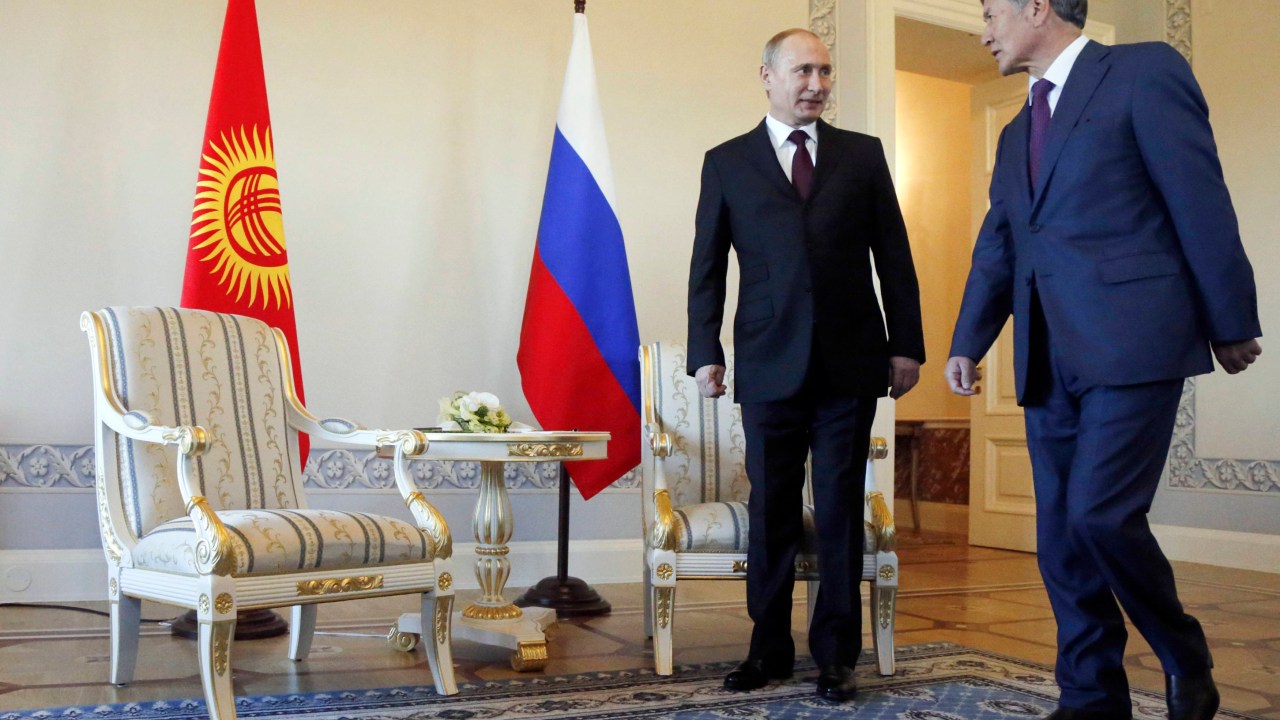 Vladimir Putin (esq) durante reunião com o presidente do Quirguistão, Almazbek Atambayev, em São Petersburgo