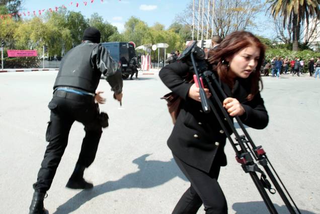 Policial corre do lado de fora do Parlamento de Túnis, na Tunísia. Terroristas atacaram nesta terça-feira o museu nacional, que fica perto do parlamento, deixando mais de 20 mortos