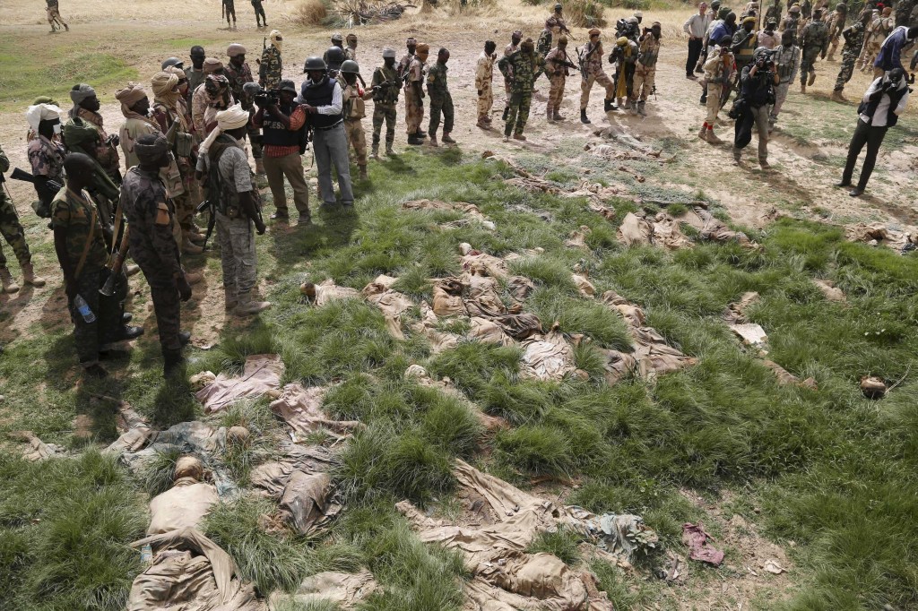 Soldados do Chade e jornalistas observam local onde dezenas de corpos foram encontrados perto da cidade de Damasak, na Nigéria, retomada das mãos dos terroristas do Boko Haram